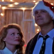 the Griswolds looking at the sky in front of a house with Christmas lights
